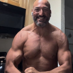 Muscular man posing in a kitchen