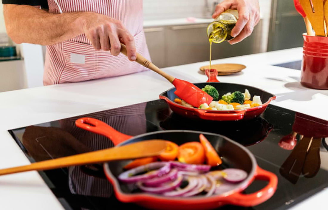 close up of man sautéing vegetables in a pan with oil