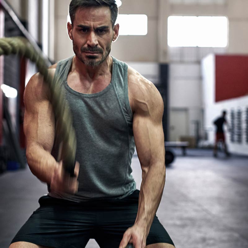 Man exercising with resistance ropes in a gym setting