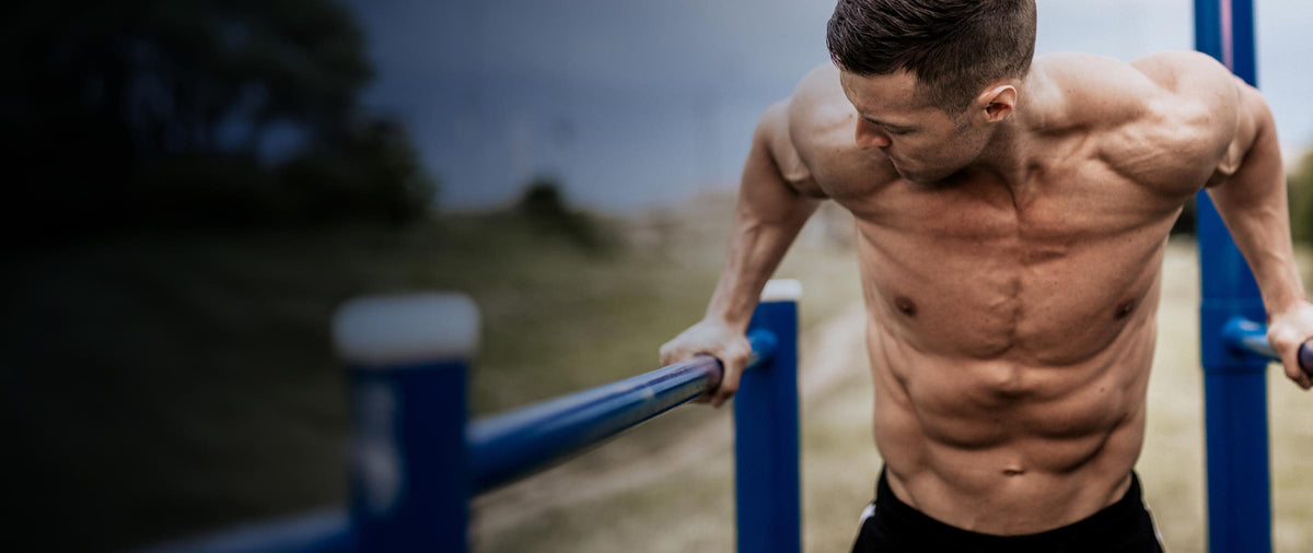 Man exercising on outdoor fitness equipment with a natural background