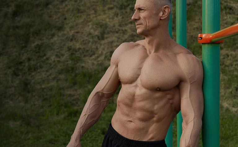Muscular man leaning against a green metal structure outdoors