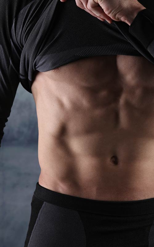 Close-up of a person wearing black underwear against a dark background